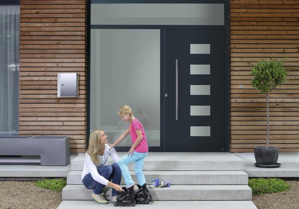 exterior shot of entrance to a home with a composite door and family in foreground