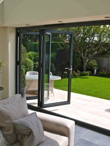 interior shot of an open black bifold door leading out to garden area