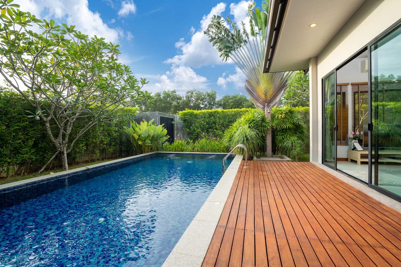 exterior picture of swimming pool attached to accommodation surrounded by foliage and decking