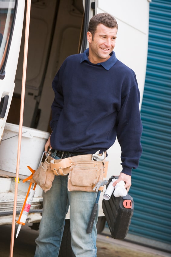 a man leaving a van wearing a utility belt full of tools